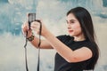 Beautiful girl standing in the room and taking selfie video for fashion blog. Woman holding compact camera in her hand and taking Royalty Free Stock Photo