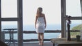 Beautiful girl stands on balcony and looking at sea horizon from luxury terrace. Royalty Free Stock Photo