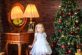 beautiful girl stands near a festive Christmas tree Royalty Free Stock Photo