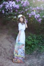 Beautiful girl in a straw hat in a lilac garden. Girl with lilac flowers in spring time. Gardening. The concept of femininity, ten Royalty Free Stock Photo