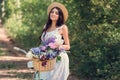 beautiful girl in straw hat and white dress posing with bicycle and flowers