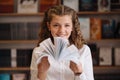 Beautiful girl is studying reading a book while standing on the floor among books in the bookshop