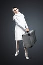 Beautiful girl with a suitcase in his hand. Isolated on a gray background. Royalty Free Stock Photo