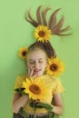 A beautiful girl with sunflowers in her blonde hair and a yellow baby manicure Royalty Free Stock Photo