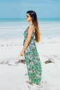 Beautiful girl in sunglasses in a bright dress on a white beach Royalty Free Stock Photo