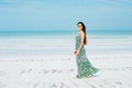 Beautiful girl in sunglasses in a bright dress on a white beach Royalty Free Stock Photo