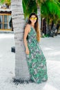 Beautiful girl in sunglasses in a bright dress on a white beach Royalty Free Stock Photo