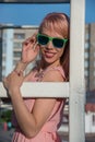 Beautiful girl in sunglasses and pink dress posing for a summer Royalty Free Stock Photo