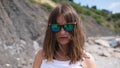 The beautiful girl in sunglasses with reflection of the cameramen on the beach