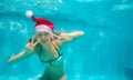 Beautiful girl swim in the pool wearing Santa hat Royalty Free Stock Photo