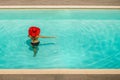 Beautiful girl in a swimsuit and a red hat in a blue water pool Royalty Free Stock Photo