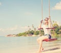 beautiful girl on a swing against the background tropical seascape Royalty Free Stock Photo