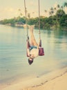 beautiful girl on a swing against the background tropical seascape Royalty Free Stock Photo