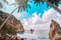 Beautiful girl on swing coconut palms on beach at Daimond  beach, Nusa Penida island Bali ,Indonesia Royalty Free Stock Photo