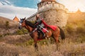 A beautiful girl with a sword in a medieval fantasy suit. A woman in a chain mail, crown, on a horse in combat ammunition. A girl Royalty Free Stock Photo