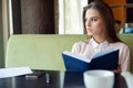 Beautiful girl at a table in a cafe with a notebook