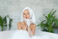 Girl taking bath with bubble foam at home.