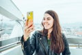 Beautiful girl taking picture at Ferris wheel on her phone Royalty Free Stock Photo