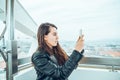 Beautiful girl taking picture at Ferris wheel on her phone Royalty Free Stock Photo