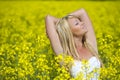 A beautiful girl taking in rays in a yellow field Royalty Free Stock Photo