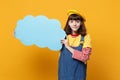 Beautiful girl teenager in french beret, denim sundress hold blue empty blank Say cloud speech bubble isolated on yellow Royalty Free Stock Photo