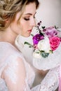 Beautiful girl in tender lacy dress with bouquet flowers peonies in hands standing against floral background in flower shop. Joyfu Royalty Free Stock Photo