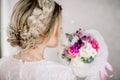 Beautiful girl in tender lacy dress with bouquet flowers peonies in hands standing against floral background in flower shop. Joyfu Royalty Free Stock Photo