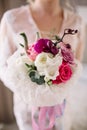 Beautiful girl in tender lacy dress with bouquet flowers peonies in hands standing against floral background in flower shop. Joyfu Royalty Free Stock Photo