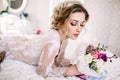 Beautiful girl in tender lacy dress with bouquet flowers peonies in hands standing against floral background in flower shop. Joyfu Royalty Free Stock Photo