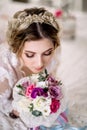 Beautiful girl in tender lacy dress with bouquet flowers peonies in hands standing against floral background in flower shop. Joyfu Royalty Free Stock Photo