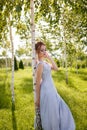 Beautiful girl in tender prom dress among green birch trees. Female portrait Royalty Free Stock Photo