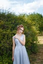 Beautiful girl in tender prom dress on green bush background. Female portrait Royalty Free Stock Photo