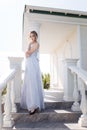 Beautiful girl in tender prom dress on stairs background. Female portrait Royalty Free Stock Photo