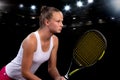 Beautiful girl tennis player with a racket on dark background with lights Royalty Free Stock Photo