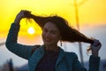 Beautiful girl touches her red hair on the background of the setting sun Royalty Free Stock Photo