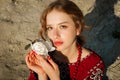 A beautiful girl in a traditional ethnic red dress posing outdoors with a white peony flower in her hand Royalty Free Stock Photo