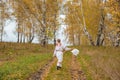 Beautiful girl in a traditional Slavic dress with a straw basket in her hands walks in the autumn forest Royalty Free Stock Photo