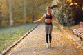 Sports girl in a black top training in a autumn park