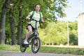 Beautiful girl traveling on electric bike, active young woman riding bicycle, female biking in park, in nature at summer Royalty Free Stock Photo