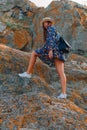 Beautiful girl travels in a hat with a beautiful smile on the background of mountains and sky Royalty Free Stock Photo