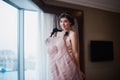 Beautiful girl tries on a pink wedding dress