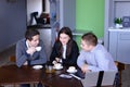 Three businessmen, woman and men discussing robot with cup of te Royalty Free Stock Photo