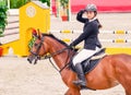 Beautiful girl in uniform and bay dressage horse at showjumping competition. Royalty Free Stock Photo