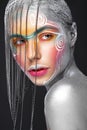 Beautiful girl in an unusual winter look with colorful face. Creative make- up. Art look