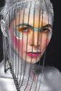 Beautiful girl in an unusual winter look with colorful face. Creative make- up. Art look
