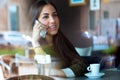 Beautiful girl using her mobile phone in cafe. Royalty Free Stock Photo