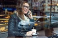 Beautiful girl using her mobile phone in cafe. Royalty Free Stock Photo