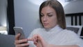 Beautiful Girl Using Smartphone while Sitting in Bedroom Royalty Free Stock Photo