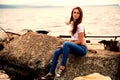 Beautiful girl using smartphone sitting on an old pier Royalty Free Stock Photo