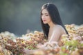 Beautiful girl in vintage dress and hat standing near colorful flowers Royalty Free Stock Photo